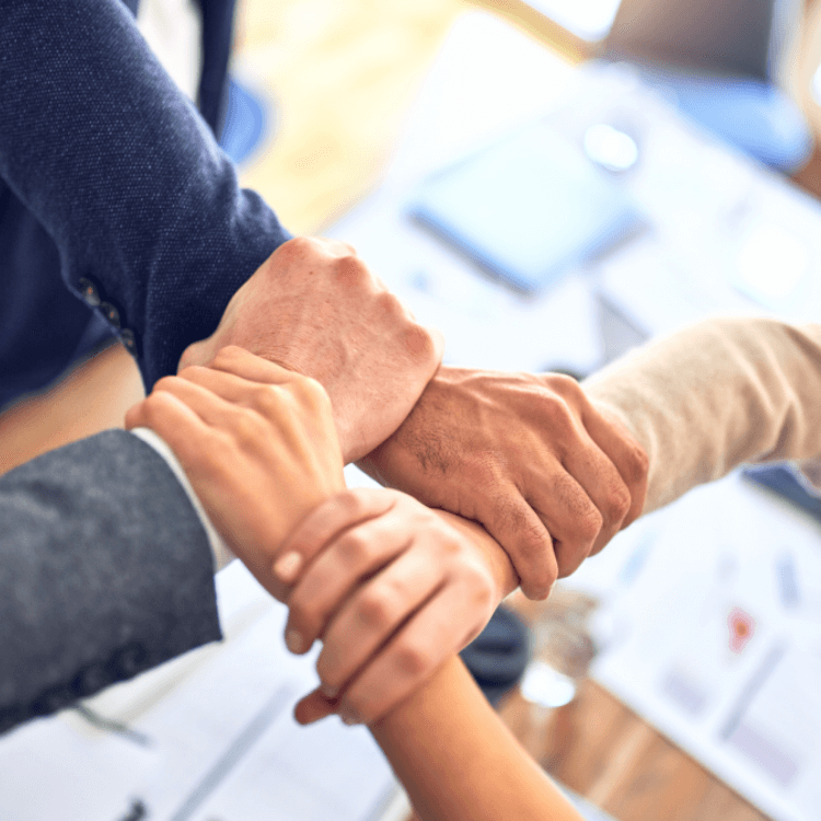 Et bilde av fire hånd som holder hverandre